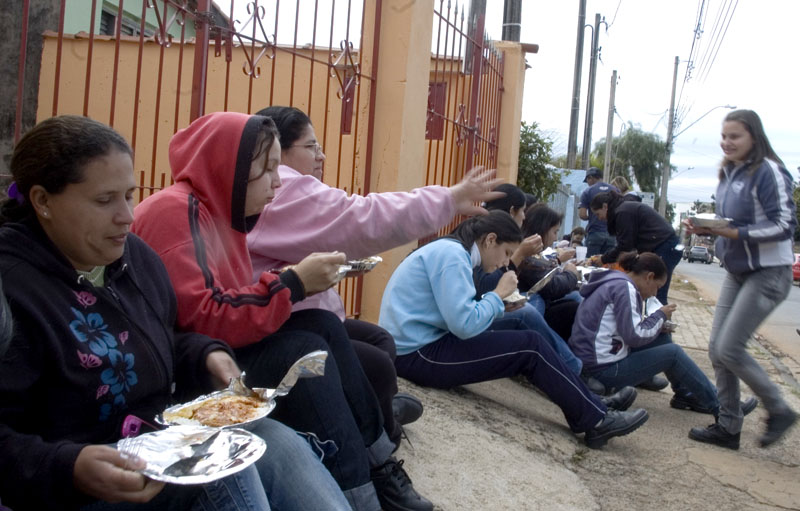 Trabalhadores almoçam do lado de fora do pátio da fábrica após a paralisação se deflagrada