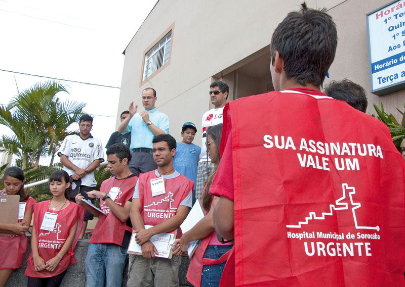 Padre Fausto Culbert, da paróquia Santa Maria dos Anjos, do Vitória Régia, abençoa voluntários durante coleta de assinaturas naquele bairro